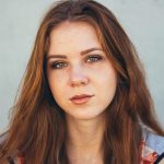 Stunning close-up portrait of a young woman with red hair and expressive eyes.